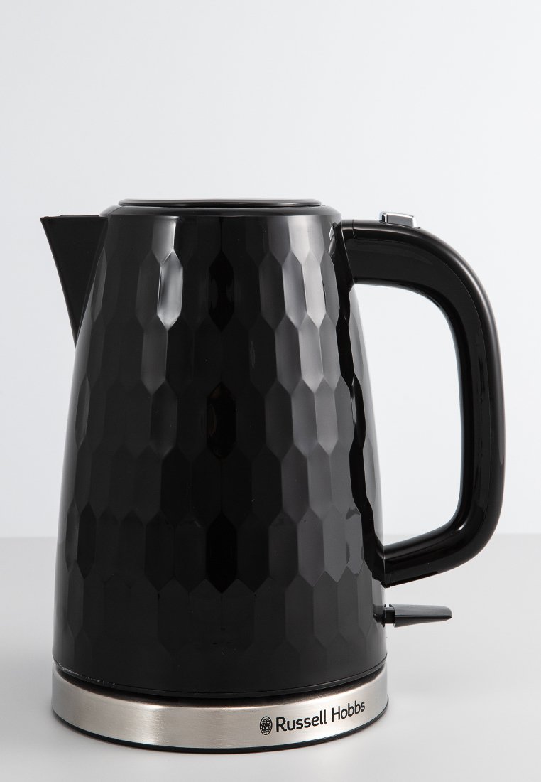 Bouilloire noire à motif hexagonal avec un manche et un bec lisses, base argentée et logo de la marque sur le bas à l'avant.