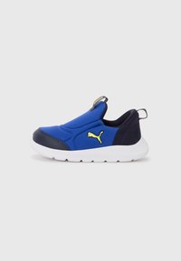 Baskets slip-on bleues avec un design rembourré, présentant des accents noirs, une semelle en caoutchouc blanche et un détail de logo jaune.