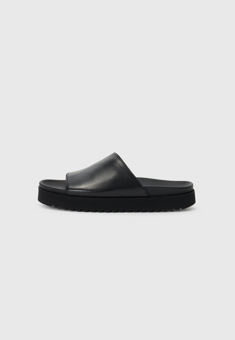 Sorte skinnsandaler i svart har en glatt overdel med en lav, tykk gummisåle og en teksturert kant for bedre grep.
