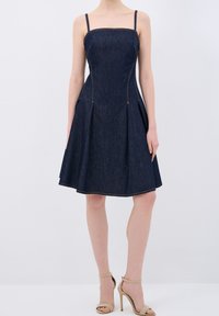 Dunkelblaues Jeanskleid mit tailliertem Oberteil, quadratischem Ausschnitt und plissiertem, ausgestelltem Rock. Verfügt über dünne Träger und kontrastierende Nähte.