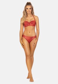 Czerwony zestaw bikini z teksturowanym wzorem węża, formowanymi miseczkami i regulowanymi ramiączkami. Majtki mają boczne akcenty dla dodatkowego detalu.