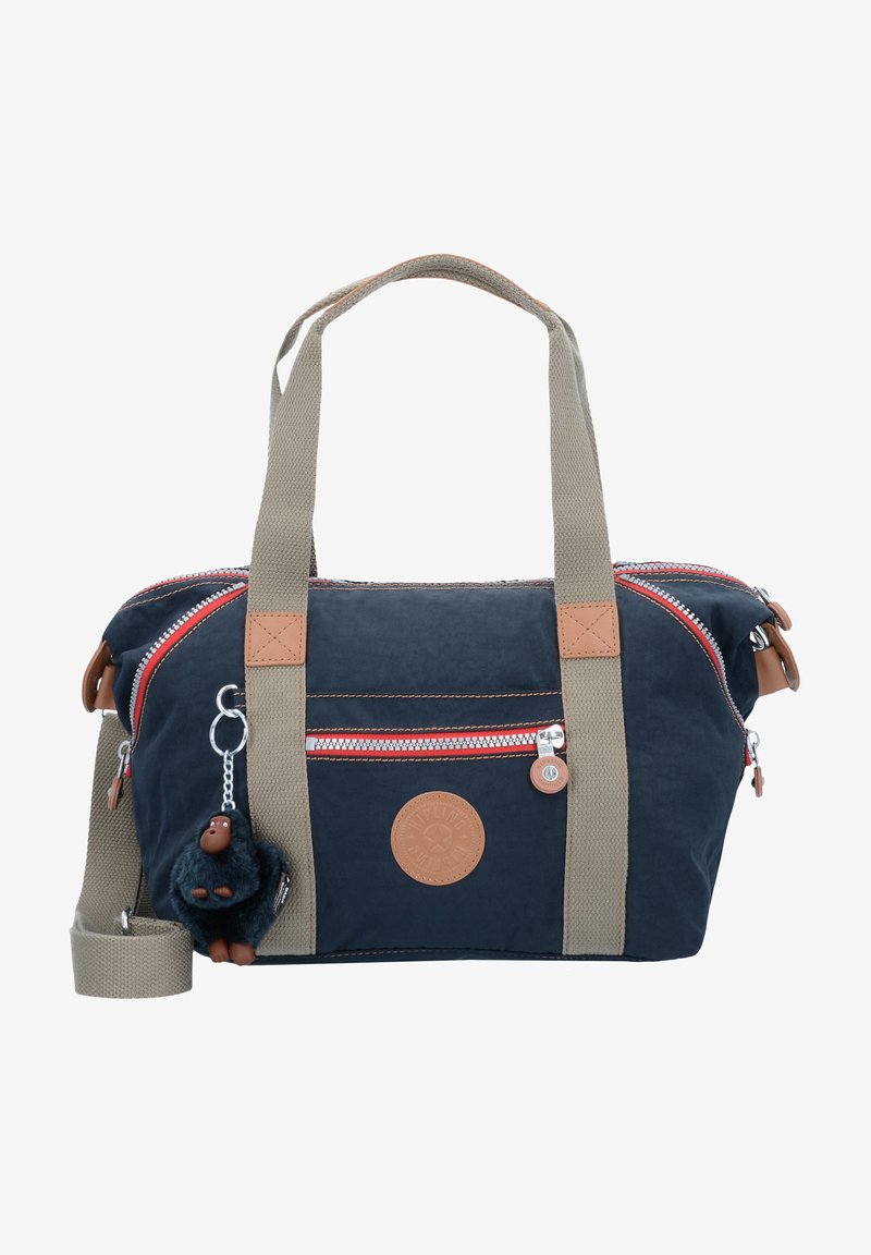 Navy fabric bag with red and white zipper accents, tan leather detailing, dual handles, and a detachable furry keychain charm.