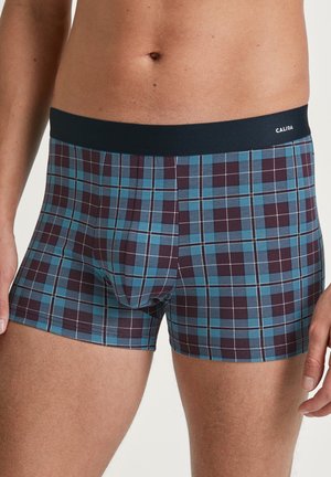 Karierte Boxershorts aus weichem Stoff, mit einem dunkelblauen Bund. Die Farben umfassen tiefes Burgunderrot, Türkis und weiße Gitterlinien.