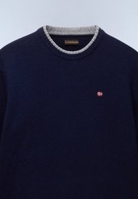 Navyblauwe gebreide trui met een grijs ribgebreide ronde hals. Bevat een kleine geborduurde Noorse vlag op de borst. Zachte textuur.