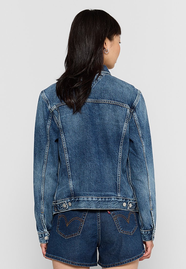 Jeansjacke in Hellblau mit klassischem Schnitt, mit gesteppten Nähten, Knopfleiste und Brusttaschen. Der Rücken hat einen leichten Schwung am Saum.