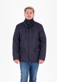 Giacca impermeabile navy con finitura testurizzata, dotata di colletto alto, due tasche anteriori e chiusure a bottone. Completata da uno strato interno con zip.