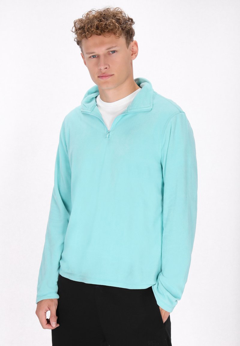 Lichtblauwe fleece pullover met een halve rits, lange mouwen en een rechte zoom. De stof lijkt zacht en glad, met een eenvoudig ontwerp.