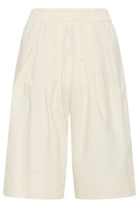 Short ample couleur crème avec taille élastique et plis subtils à l'avant, longueur genoux, tissu doux.