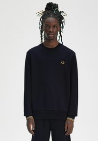 Felpa girocollo navy in misto cotone, con polsini e orlo a costine. Logo dorato sul petto e dettagli a strisce a contrasto sulle maniche.