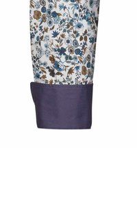 Tessuto a fantasia floreale in blu, bianco e marrone con un polsino solido di un viola scuro. Il tessuto presenta vari piccoli fiori e foglie.