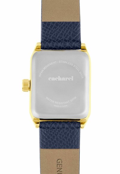 Vierkante gouden achterkant van een horlogekast met gegraveerde tekst "cacharel", donkerblauwe, gestructureerde leren band en gouden kroon op een witte achtergrond.