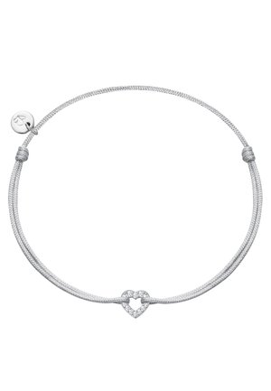 Pulsera de cordón ajustable de plata con un pequeño colgante en forma de corazón adornado con diamantes en el centro y un colgante redondo con un grabado de corazón cerca del nudo.