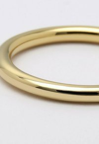 Gouden armband met een glad, afgerond ontwerp en glanzende afwerking, met een naadloze, doorlopende vorm.