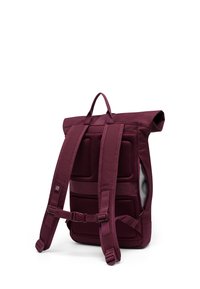 Sac à dos rouge bordeaux à rabat, avec panneau arrière rembourré, bretelles réglables, boucle de poitrine et poche latérale, présenté de dos sur fond blanc.