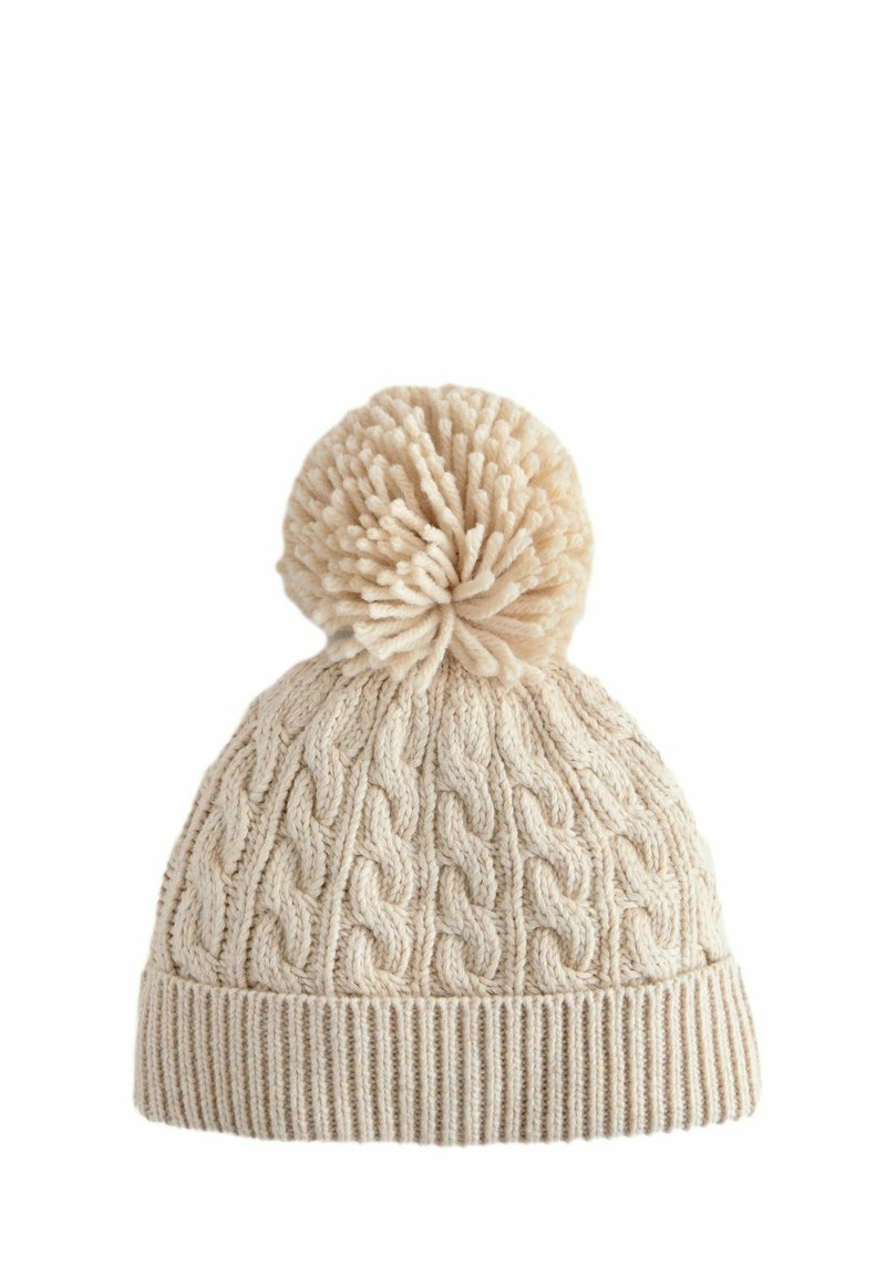 Bonnet en tricot couleur crème avec un motif de cable texturé, doté d'un grand pompon duveteux sur le dessus et d'un revers côtelé en bas.