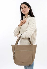 Taupe leren tote bag met een gladde afwerking, dubbele handgrepen bovenaan en een voorvak met rits. Beschikt over een gestructureerde vorm, ideaal voor dagelijks gebruik.