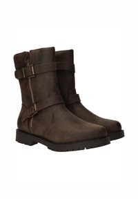 Bottes de cheville en simili cuir marron, avec un bout rond, des zips sur le côté et deux sangles ajustables fixées par des boucles. Tige texturée et semelle en caoutchouc.
