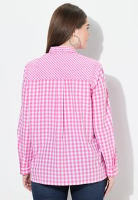 Langärmliges Hemd mit einem rosa-weißen Karomuster, umlegbarem Kragen und plissiertem Rückendesign. Der Stoff scheint glatt zu sein.