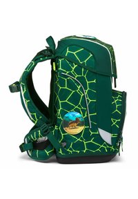 Grüner Rucksack mit einem geometrischen Muster in Grün und Gelb, ausgestattet mit einem Löwen-Abzeichen, mehreren Taschen und verstellbaren Trageriemen.