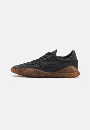 Baskets en cuir noir avec semelle en caoutchouc marron texturée et lacets noirs, vues de côté extérieur sur fond blanc.