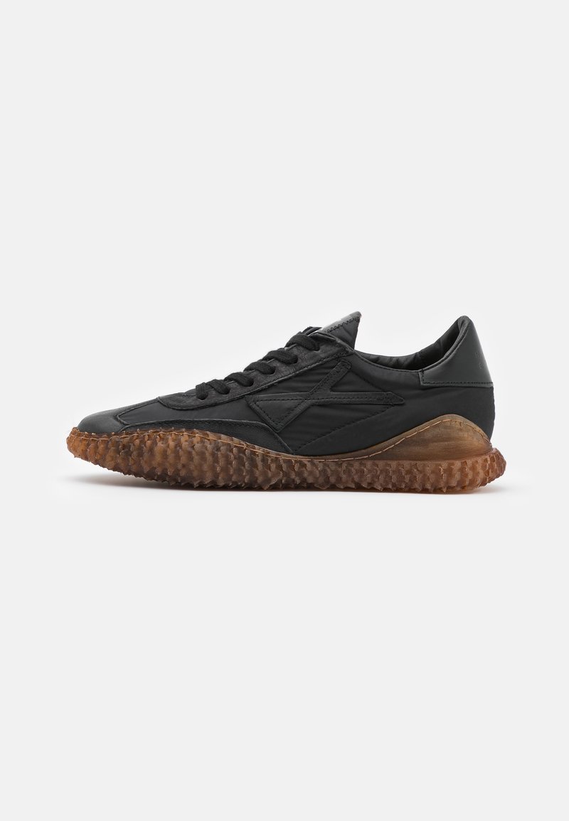 Baskets en cuir noir avec semelle en caoutchouc marron texturée et lacets noirs, vues de côté extérieur sur fond blanc.