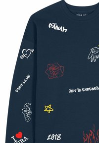 Marineblauwe sweatshirt met verschillende geborduurde ontwerpen, waaronder een roos, hart, slang, ster en vlam. Tekstelementen in contrasterende kleuren.