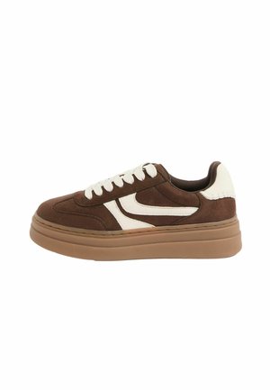Brown suede sneaker with white accents, round toe, flat sole, and perforated detailing; features lace-up closure and contrasting stitching.