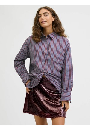 Stribet skjorte med knapper i marineblå og rød, kombineret med en bordeaux paillet mininederdel; har lange ærmer og løs pasform.