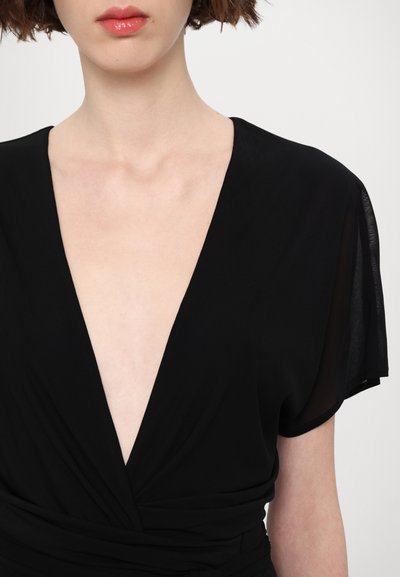 Vestido negro con escote en V profundo, mangas cortas acampanadas y una textura de tela suave, con una cinturilla fruncida.