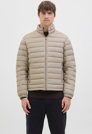 Chaqueta acolchada beige con cuello alto, cremallera frontal y puños elásticos. Cuenta con un dobladillo acanalado y bolsillos laterales para mayor funcionalidad.