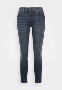 Jeans de mezclilla azul oscuro con un ajuste slim, que cuentan con un cierre de botón, diseño de cinco bolsillos y un ligero desvanecimiento en la tela.