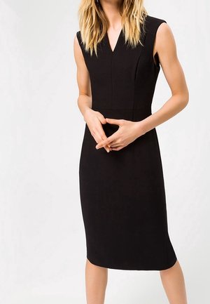 Robe sans manches noire avec un col en V, corsage ajusté et jupe à mi-cuisse. Tissu lisse avec des détails de couture subtils.
