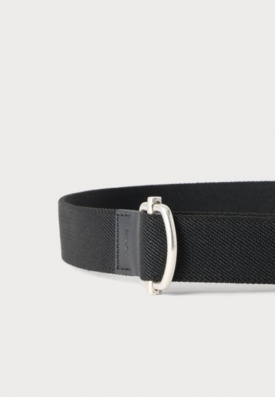 Ceinture en tissu tissé noir avec boucle rectangulaire argentée et détail en cuir cousu sur fond clair.