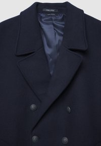 Cappotto in misto lana blu navy con design doppiopetto, ampi risvolti e due bottoni metallici. Interno foderato con tessuto di satin scuro.