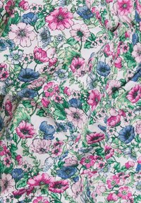 Tessuto con stampa floreale che presenta fiori rosa, blu e verdi su uno sfondo bianco. Il design include varie forme di fiori e lussureggianti foglie verdi.