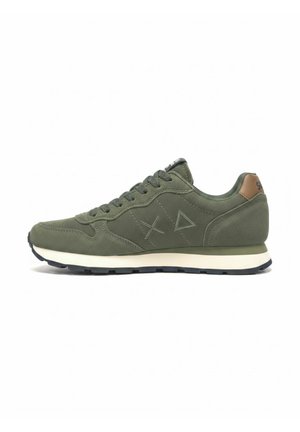 Donkergroene suède sneaker met veters aan de voorkant, lichte zool en geperste kruis- en driehoeksvormen aan de zijkant, met bruine hieltab.