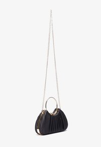 Sac à main noir plissé avec un cadre en métal doré, une poignée circulaire et une bandoulière en chaîne. Présente une surface texturée et une forme courbée.