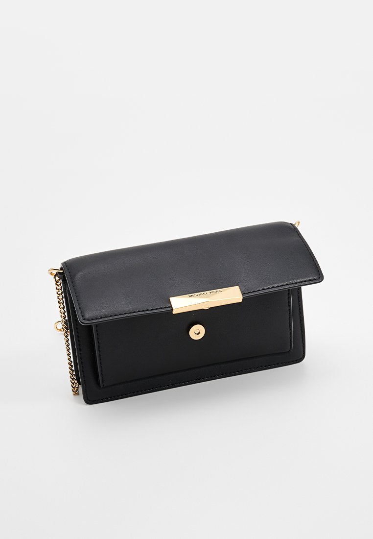 Czarna skórzana torebka na ramię z klapką, złotymi detalami i łańcuszkowym paskiem. Posiada gładką teksturę oraz metalową płytkę z akcentem.