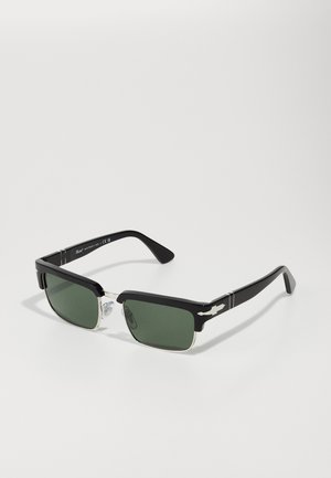 Gafas de sol rectangulares negras con lentes verdes, acentos plateados en los laterales, almohadillas nasales transparentes y brazos de plástico elegantes.