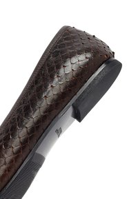 Donkerbruine leren schoen met een gestructureerd, schubachtig patroon. Licht afgeronde neus, platte rubberen zool en een minimalistisch ontwerp.