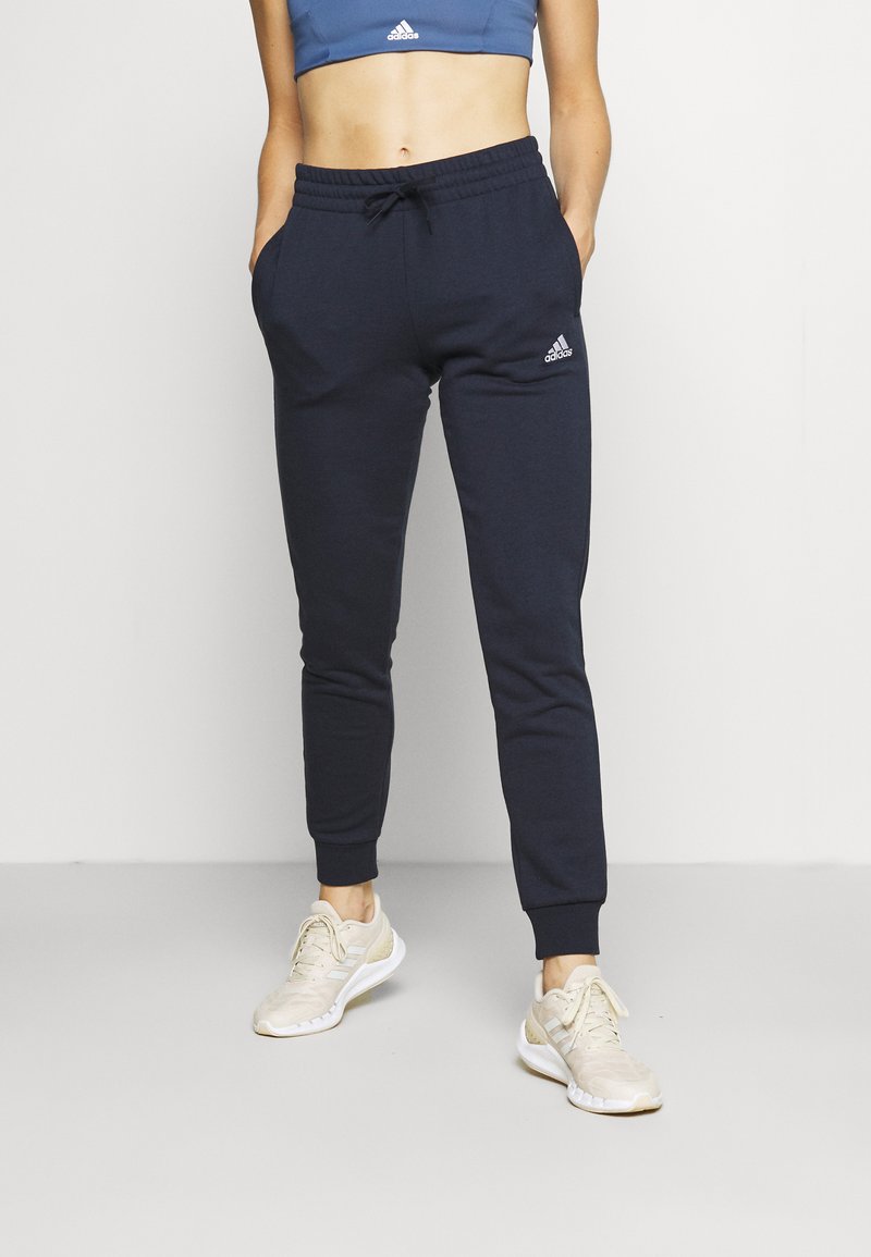Joggers de mezcla de algodón en azul marino con cintura elástica, tobillos con puños y bolsillos laterales. Presenta un pequeño logo blanco en el muslo izquierdo.