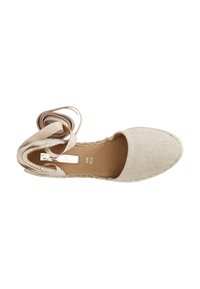Espadrille in canvas beige con punta rotonda, suola cucita color marrone e lunga fascia da legare alla caviglia, vista dall'alto.
