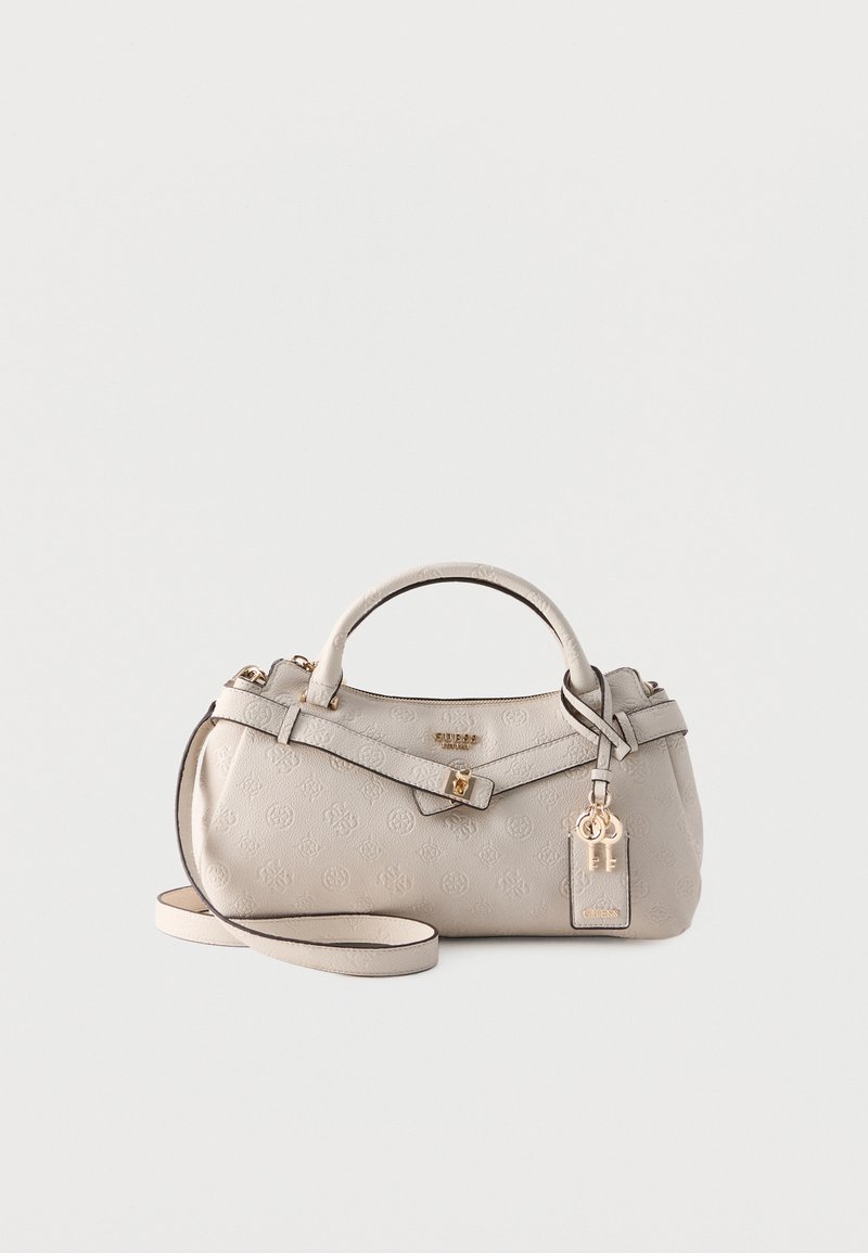 Sac à main Guess couleur crème avec motif logo embossé, poignée supérieure, bandoulière amovible, quincaillerie dorée et breloque clé marquée sur fond blanc.
