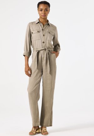 Combinaison gris clair à manches longues avec un devant boutonné, des poches poitrine, une taille à nouer et des jambes larges. Tissu lisse et texturé ; pas de motifs visibles.