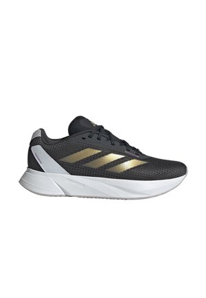 Scarpa sportiva nera con dettagli dorati, tomaia in rete, lacci tonali e suola in gomma bianca. Presenta un design elegante e moderno con una texture traspirante.