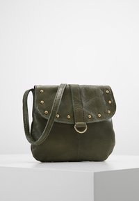 Borsa a tracolla in pelle verde con patta pieghevole, borchie dorate, una cinghia centrale con anello e finitura testurizzata. Design compatto.
