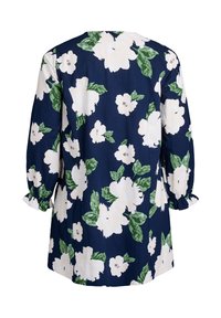 Blumen-Tunika-Kleid in Marineblau mit großen weißen Blumen und grünen Blättern, ausgestattet mit langen Ballonärmeln und Rüschensäumen.