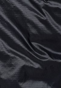 Svart tyg med ett subtilt rutmönster, som visar mjuka veck och ljusreflektioner som skapar textur och djup.