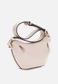 Borsa a mano in pelle beige con forma curva, rifinitura nera a contrasto e manico superiore. Dettagli in metallo dorato con superficie testurizzata.