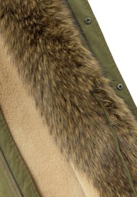 Chaqueta verde oliva con un lujoso ribete de piel marrón en el cuello y un suave forro interior en beige, con cierre de cremallera y botones a presión.